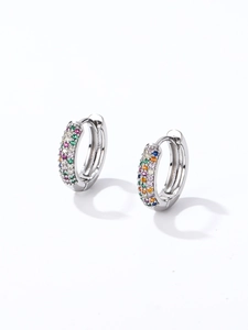 Détail des boucles d'oreilles créoles argentées serties de pierres précieuses colorées