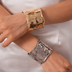 Bracelets larges martelés en or et argent avec un design texturé et une finition métallique