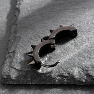 Punk style black stainless steel hoop earrings with conical studs on slate background