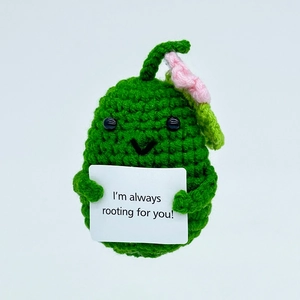 Detail of a green crochet pear toy holding an I am always rooting for you support card