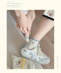 Close-up of cute dog embroidery and knit texture on cream white cotton ankle socks