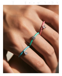 Close-up of three colorful enamel rings with zircon stones on a female hand