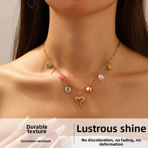 Detail of gold-plated stainless steel necklace with multi-element heart and floral charms