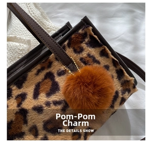 Detail shot of leopard print bag texture featuring a soft brown faux fur pom pom charm