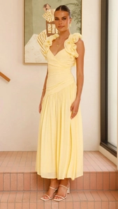 Détail de robe longue jaune élégante avec col en V, volants aux épaules et taille plissée