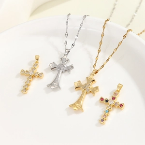 Makroansicht von vier Kreuzanhängern mit Zirkonia in Gold- und Silberschmuck-Optik