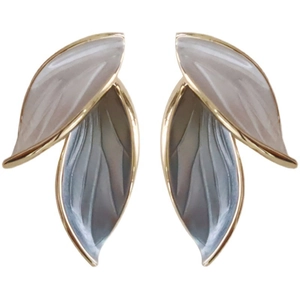 Close-up of elegant leaf-shaped stud earrings with gold trim and dual-tone enamel finish