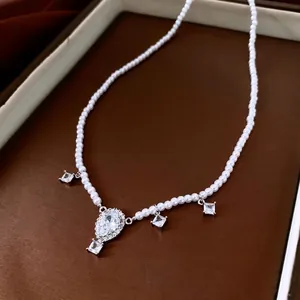 French luxury pearl necklace featuring a teardrop crystal pendant and silver accents