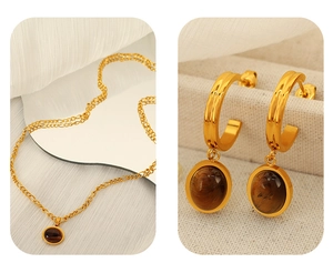 Dettaglio della collana vintage dorata e orecchini occhio di tigre su tessuto elegante