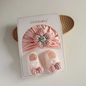 Pink infant headband and socks set with plaid flower detail on white packaging