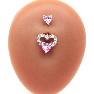 Pink heart-shaped navel ring with crystal drop shown on a silicone belly model