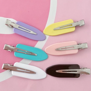 Lot de six pinces à cheveux colorées en plastique avec clip métallique sur fond rose