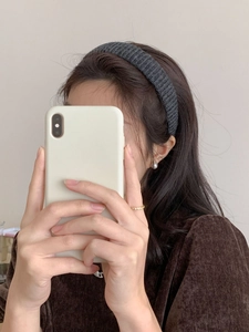 Détail du large bandeau tricoté main gris foncé avec des bijoux élégants et raffinés