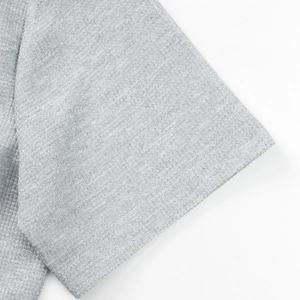 Vista macro detallada de la textura del tejido gofrado gris en una camisa de hombre