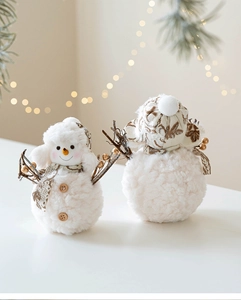 Detail of plush snowman figurines with floral scarves and soft texture for holiday decor