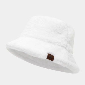 Detailed close-up of white plush bucket hat featuring a brown leather snowflake patch