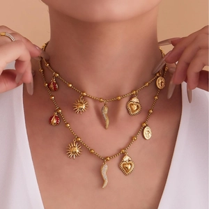 Double-layered gold bead necklace with sun, heart, and cornicello pendants on a model
