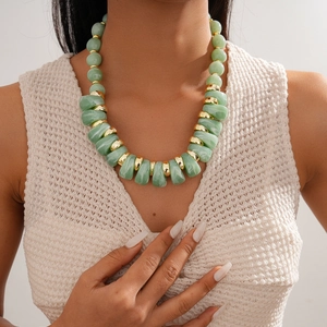Detail of chunky green acrylic beads and gold spacers on a statement sweater necklace
