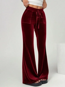 Detailed view of burgundy velvet flare pants featuring a drawstring waist and soft texture
