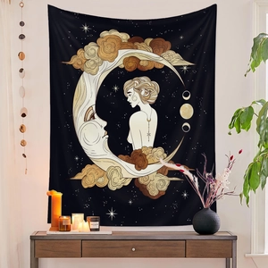 Detail of bohemian wall tapestry featuring gold moon goddess and celestial motifs on black