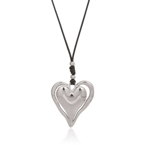 Détail macro du pendentif coeur en argent sur un collier de cordon noir avec reflets