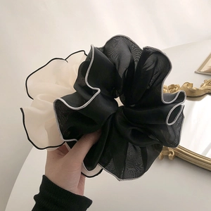 Close-up of a large black and cream contrast chiffon mesh scrunchie with fine stitching