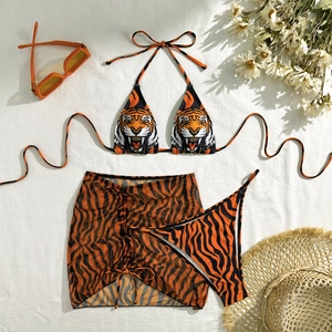 Three-piece bikini set with tiger print, orange accents and matching mesh cover-up skirt