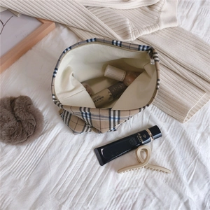 Detailed top view of a large check pattern makeup bag with metallic zipper and cosmetics