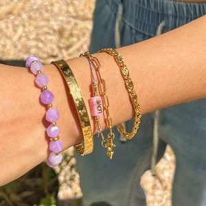 Stacked bracelet set featuring purple crystal beads and gold butterfly cuff on wrist
