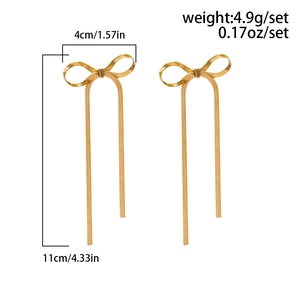 Detail view of gold bow earrings with snake chain tassels and precise size dimensions