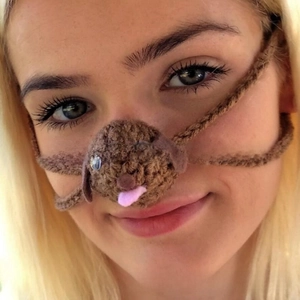 Detailed view of handmade knitted brown dog nose warmer with cute dog face features