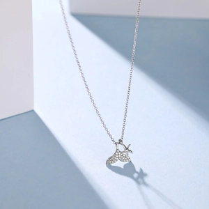 Detailed view of silver fish tail and star pendants with micro-inlaid diamond accents