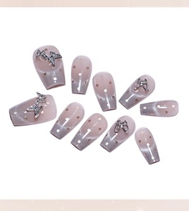 Detailed view of grey-pink gradient cat eye press-on nails with 3D silver diamond butterflies