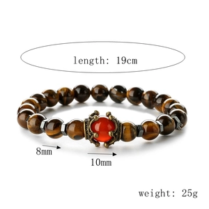 Detailed view of 8mm tiger eye bead bracelet with 10mm red center stone and vintage metal crown