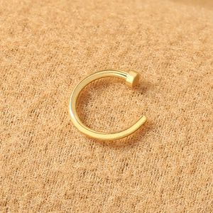 Close-up of a minimalist golden U-shaped stainless steel nose ring with high polish