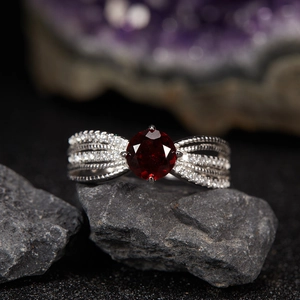 Macro shot of S925 silver ring with red garnet gemstone and twisted diamond band