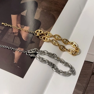 Detail of 18k gold and silver anchor link bracelets with lobster clasp on magazine