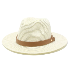 Détail de la texture tressée et du ruban en cuir marron clouté du chapeau fedora crème
