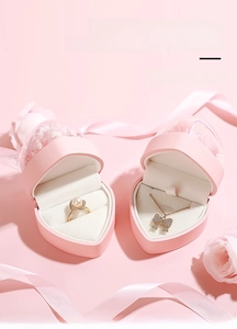 Gros plan de boîtes à bijoux en forme de cœur avec fleurs éternelles pour bague et collier