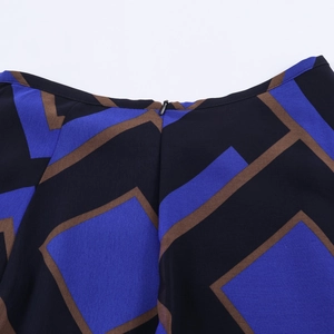 Detail van de verborgen rits en blauwe geometrische print op de geweven midi-rok