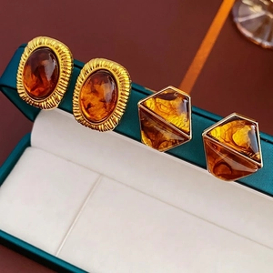 Vintage gold and amber resin geometric stud earrings on a dark green velvet box