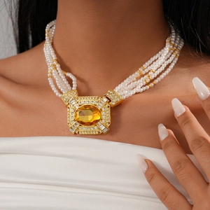 Close-up of luxury multi-layer pearl necklace with a vintage gold rhinestone pendant