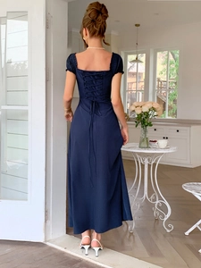Dettaglio del design con lacci sul retro dell'elegante abito lungo blu scuro a maniche