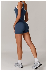 Detail of dark blue high-waisted yoga set with white contrast piping and backless vest
