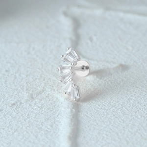 Macro shot of silver crescent earring with five fan-shaped trapezoid-cut clear gemstones