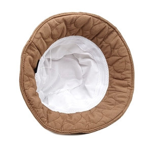 Detail of brown quilted bucket hat with heart pattern and adjustable white inner drawstring