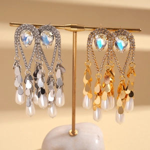 Détails macro de boucles d'oreilles pendantes plaquées or 18k avec perles et glands