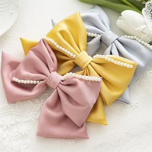 Drei elegante Satin-Haarspangen mit Schleife in Rosa, Gelb und Blau mit Perlenverzierung