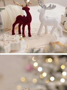 Close-up of flocking reindeer ornaments with golden antlers and festive decor