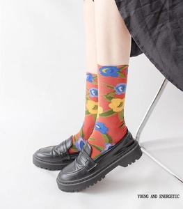 Floral crew socks in orange and blue styled with black loafers and a black skirt